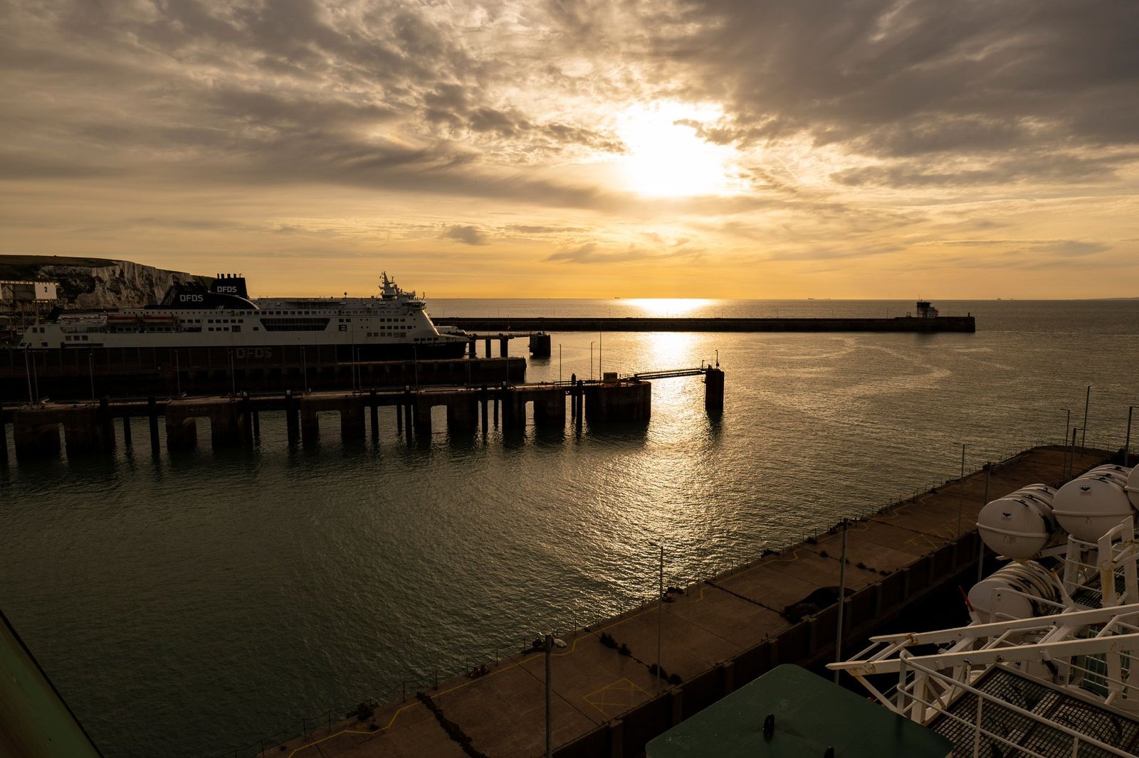 A serene sunset over Dover port with a ferry docked, capturing the peaceful maritime atmosphere.