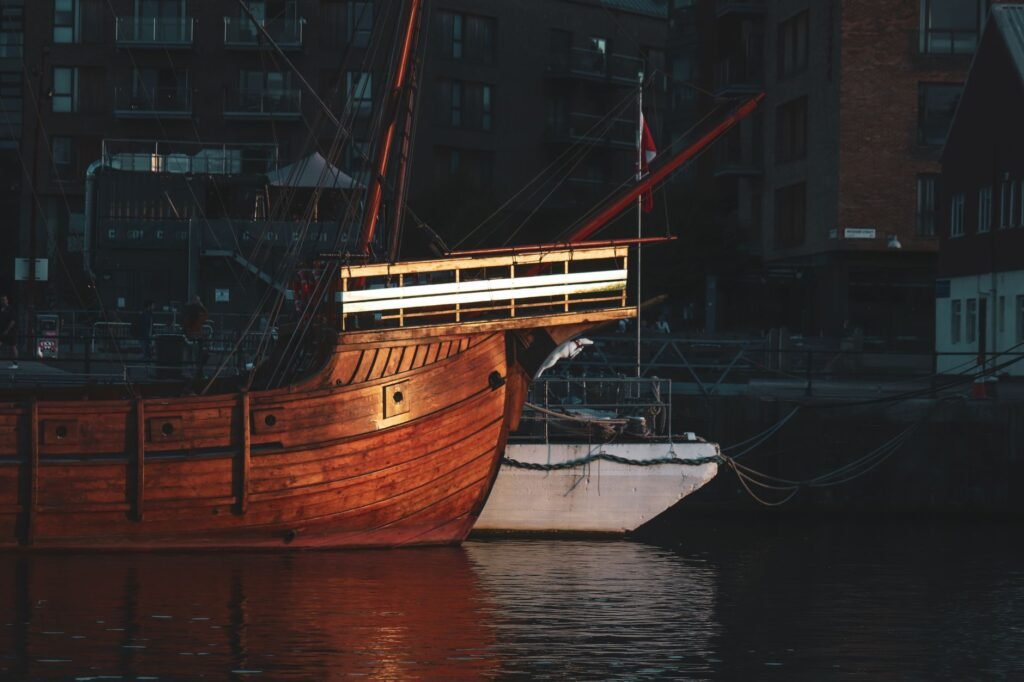 A historic wooden ship beautifully illuminated in Bristol's harbor at night.
