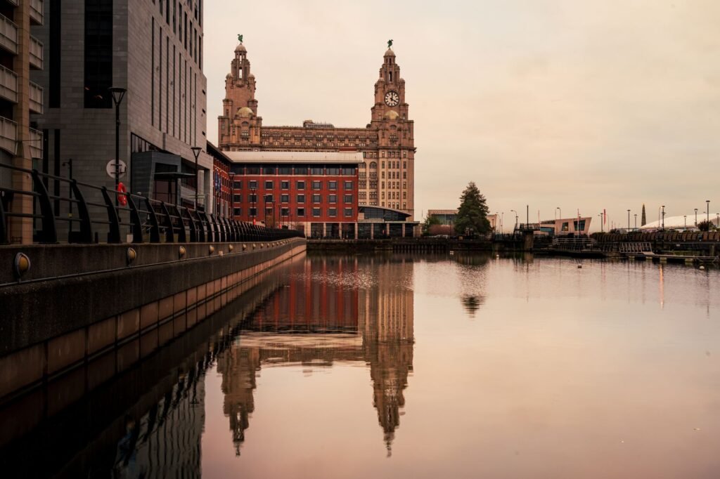 Scenic view of Liverpool's Royal Liver Building reflecting in the water on a calm day.