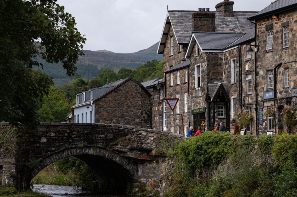 Picturesque stone buildings and a bridge in a serene village setting.