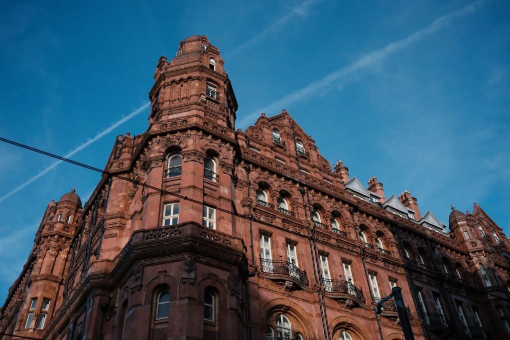 A Victorian-style building with red brick facade under a clear blue sky.