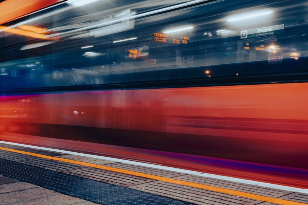 Blurred motion of a train speeding through a London station at night.