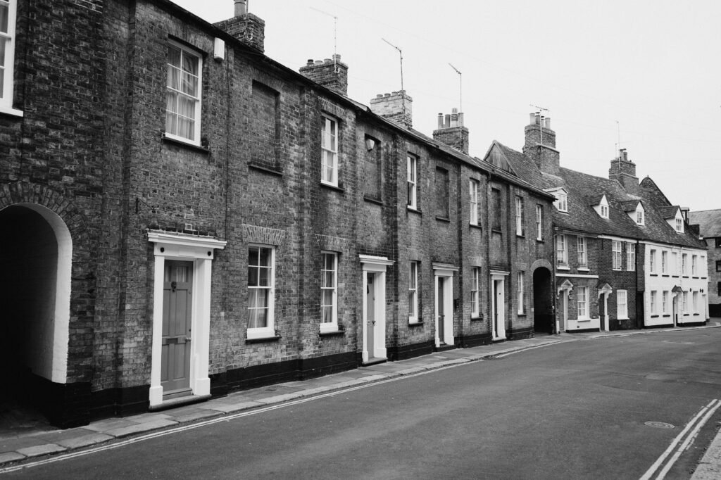Black and white photo of historic workers' cottages in King's Lynn, UK. Classic architectural style.