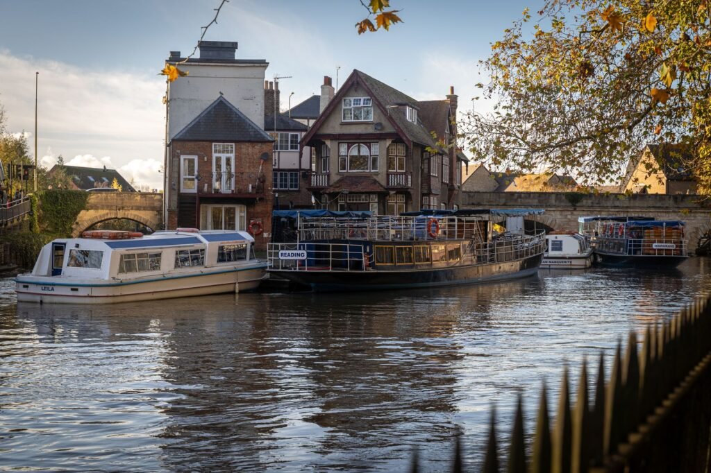 Charming boats docked near historic Folly Bridge on a sunny day in Oxford, England.