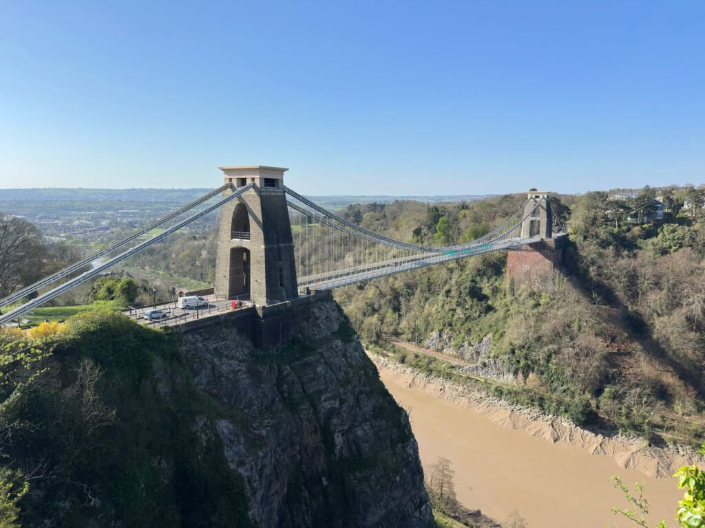 Scenic view of Clifton Suspension Bridge spanning the Avon Gorge under clear blue skies in Bristol.
