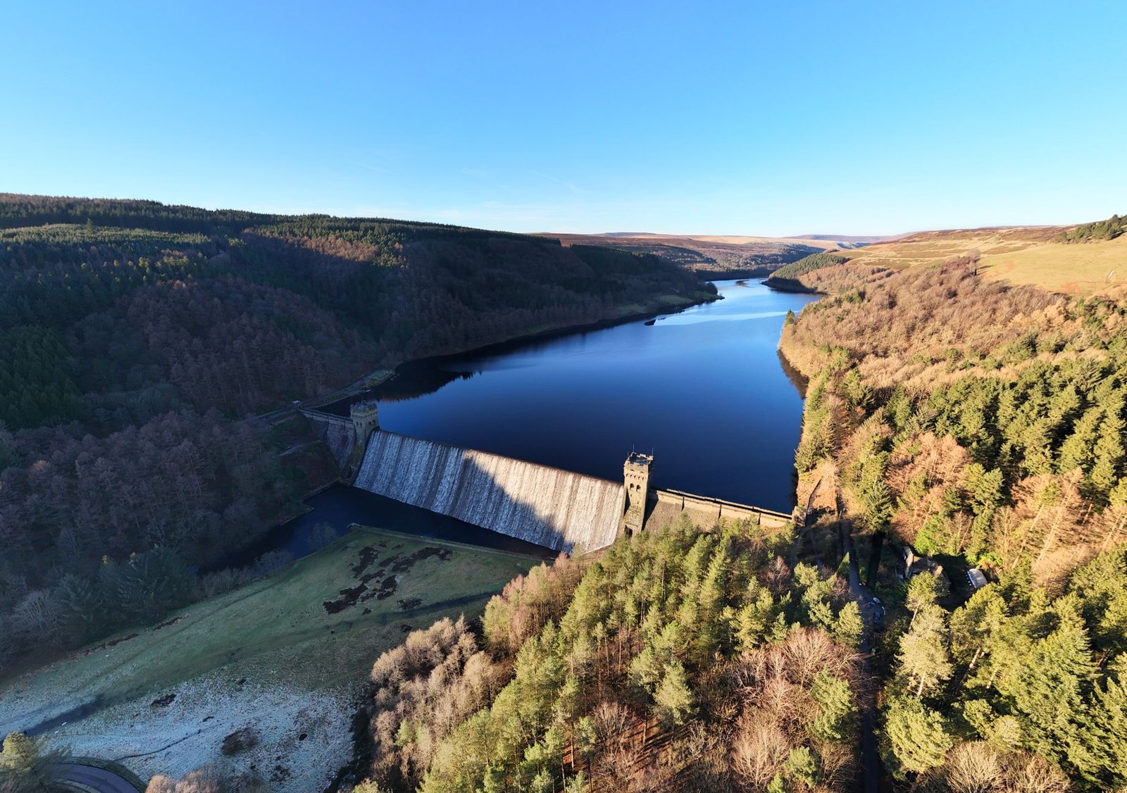 Scenic aerial view of Derwent Dam in Peak District, showcasing the serene reservoir and surrounding landscape.