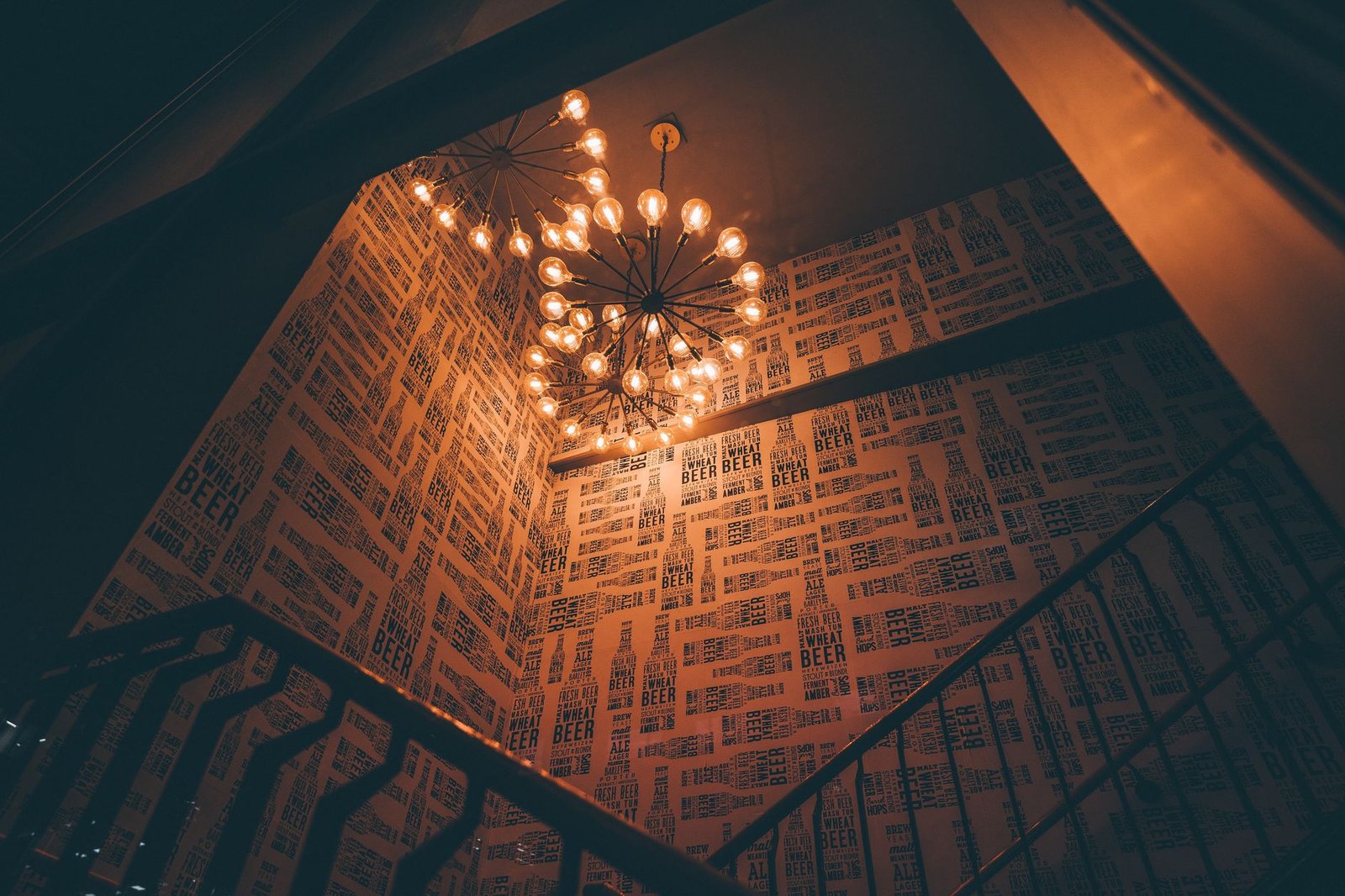 Chic industrial staircase in a London interior, adorned with a striking modern chandelier.