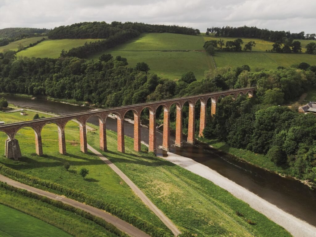 A scenic aerial shot of Leaderfoot Viaduct over River Tweed in Scotland during summer.