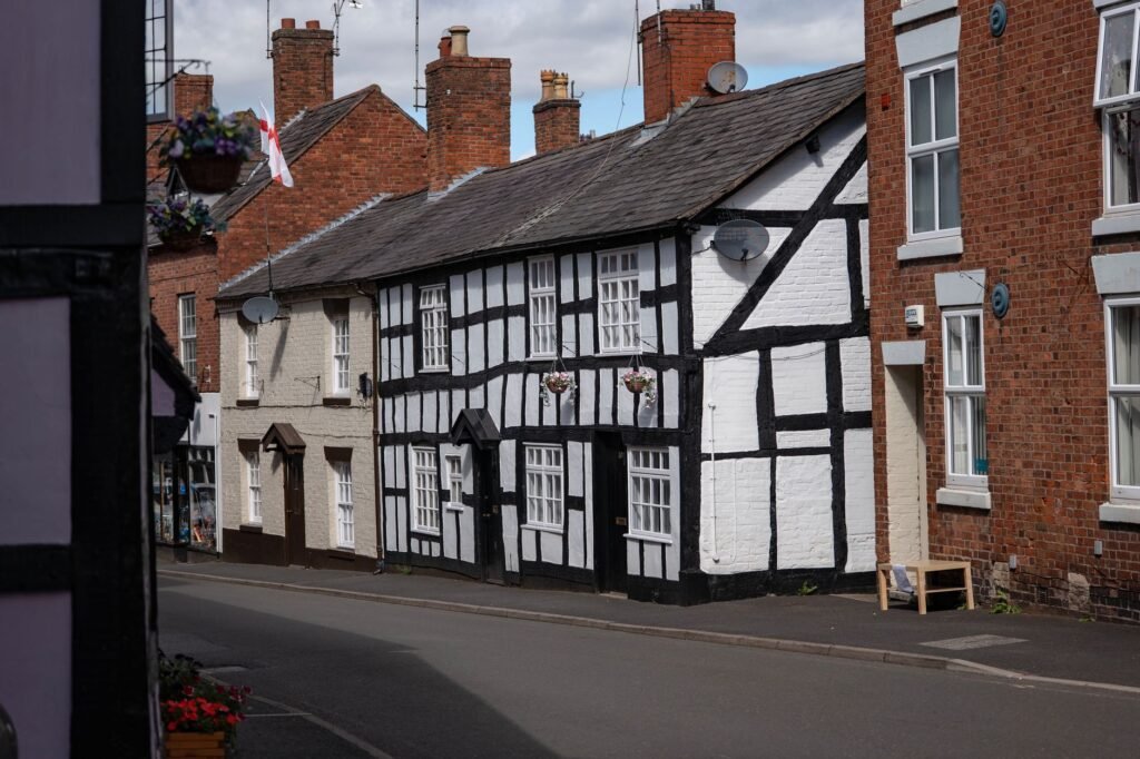 Charming half-timbered houses line a street in Whitchurch, England, showcasing traditional architecture.