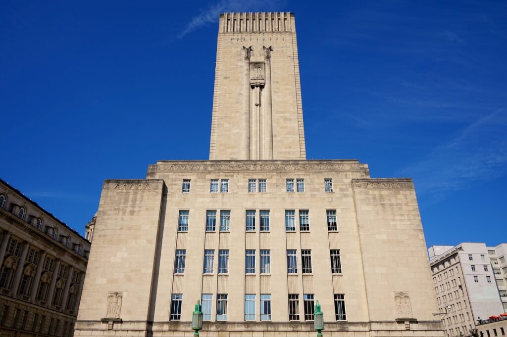 A stunning low angle view of Liverpool's iconic tower under a bright blue sky.