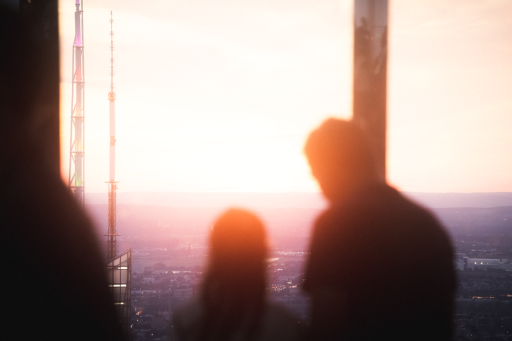 Silhouette of a couple gazing at the sunset over New York City skyline.