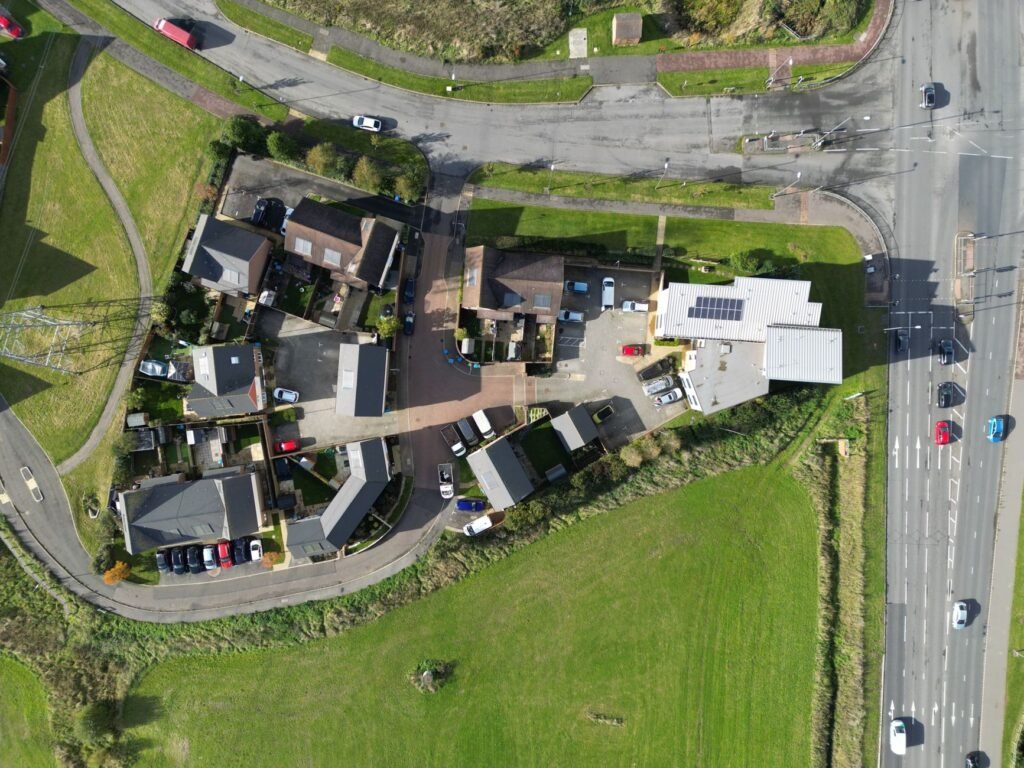 Aerial view of a residential neighborhood in Aylesbury, England, showcasing houses, roads, and parked cars.
