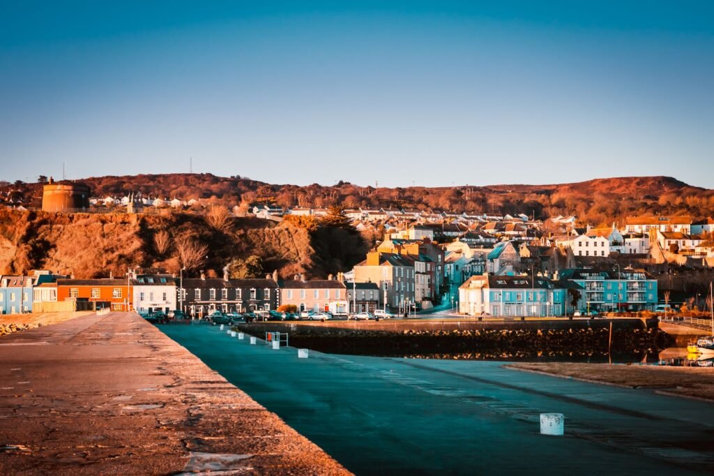 Charming coastal town with vibrant fall colors and seaside architecture at sunset.