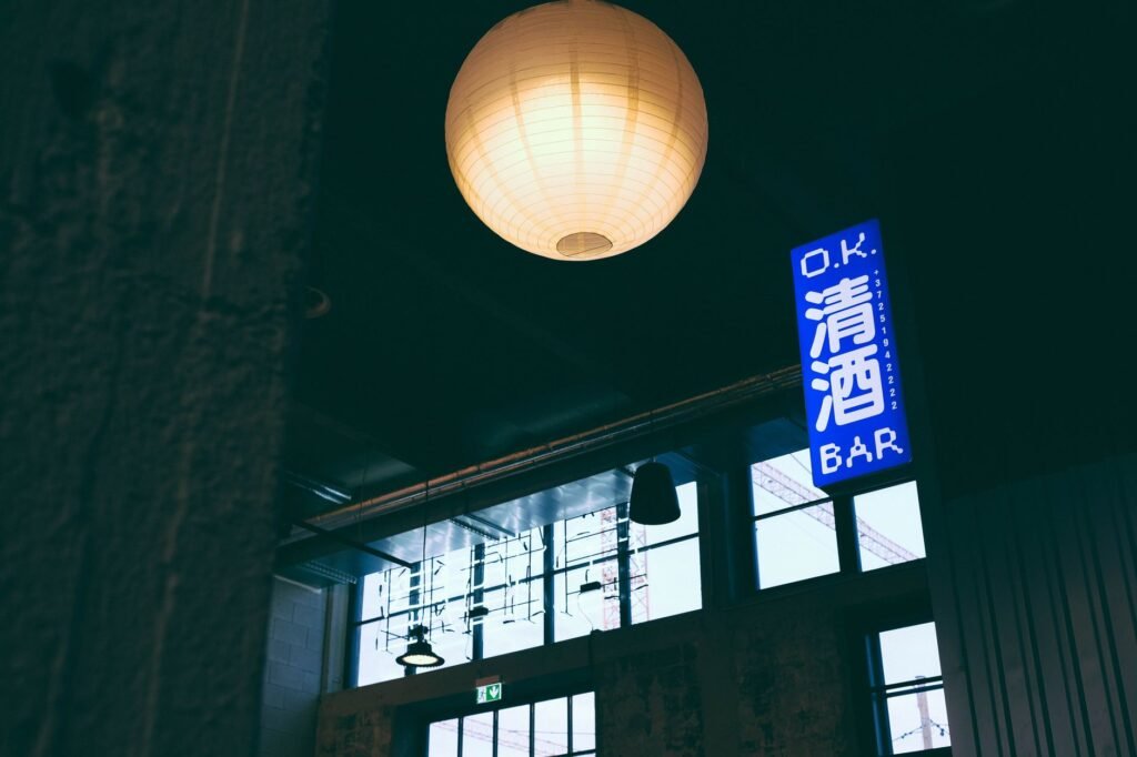 Contemporary bar scene with Japanese sign and hanging paper lanterns, creating a vibrant atmosphere.