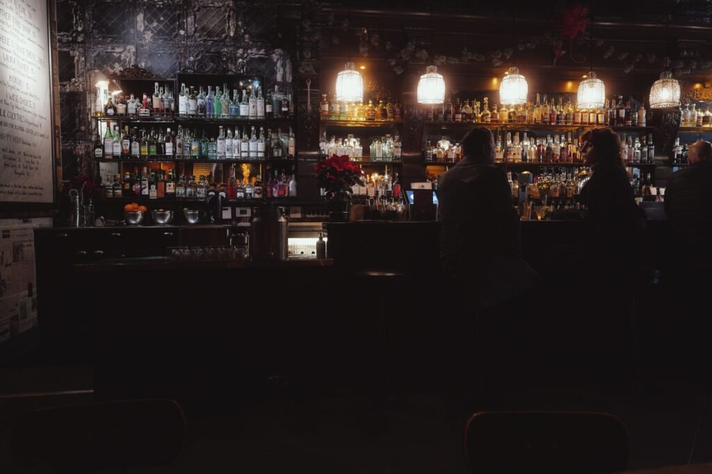Dimly lit bar with patrons enjoying drinks in San Francisco, warm and inviting atmosphere.