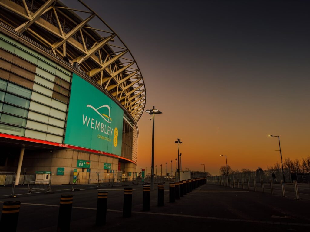 Capture of Wembley Stadium in London during dramatic twilight, showcasing its iconic architecture.