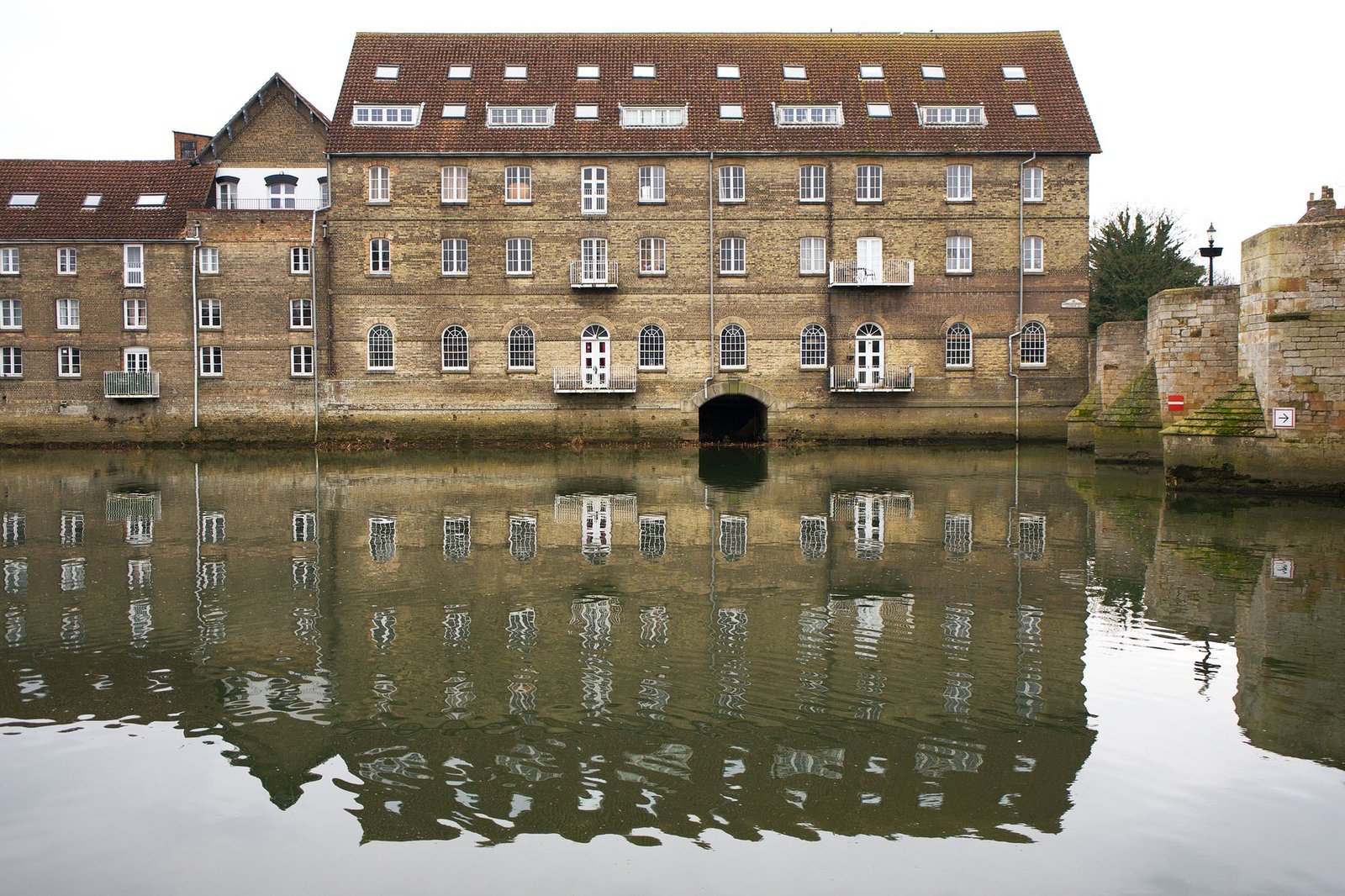 Scenic view of a historic building and its reflection in the canal at Godmanchester, England.