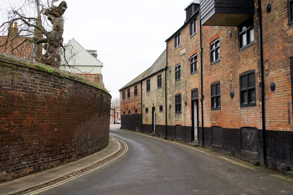 Quiet urban street in King's Lynn with historic brick buildings and curved walls.