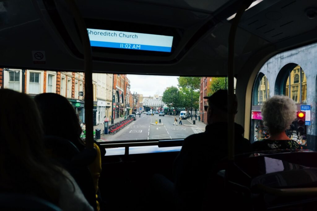 People enjoying city view from bus in Shoreditch London, showing urban scene.