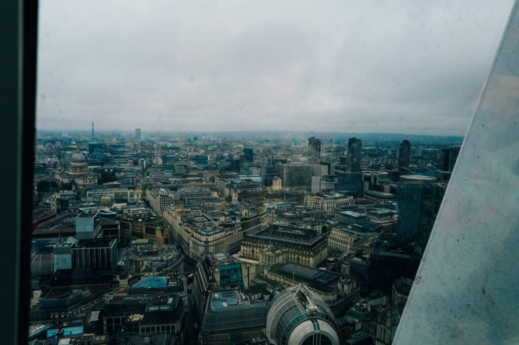 Aerial cityscape of London with iconic landmarks on a cloudy day, showcasing urban architecture.
