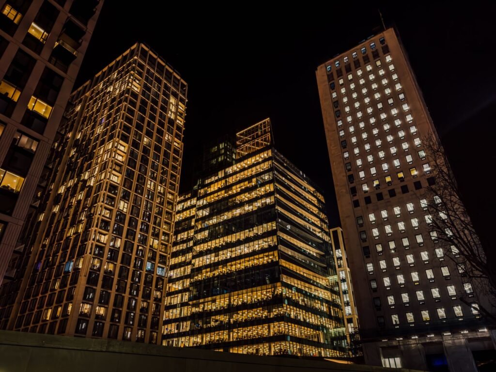 A stunning view of London's modern skyscrapers illuminated against the night sky in a vibrant urban setting.