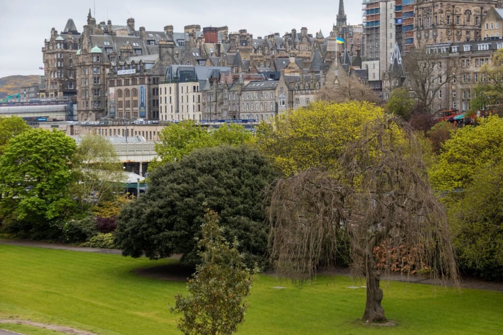 A scenic view of Edinburgh's historic architecture with lush green park foreground.