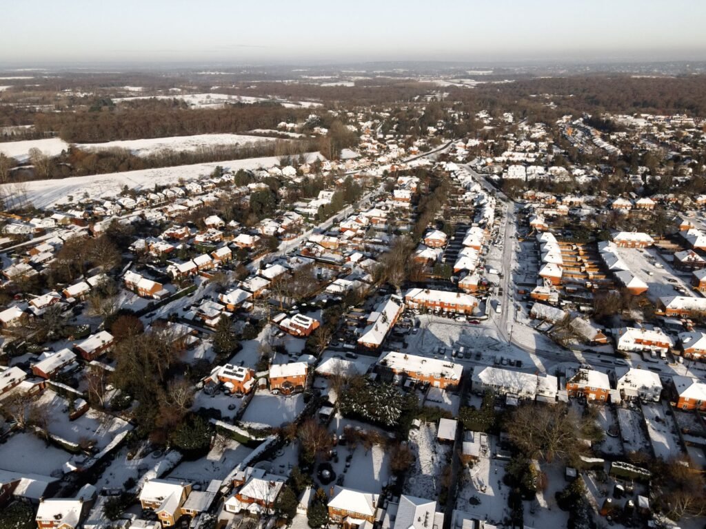 Aerial winter landscape of snow-covered houses in Leatherhead, Surrey, England.