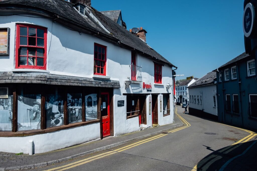 Explore the quaint streets of Kinsale, Ireland with this historic white building under a clear blue sky.