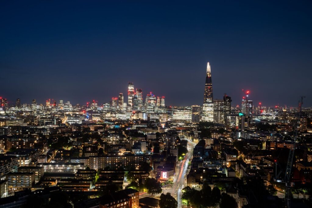 Capture a mesmerizing view of London's skyline featuring The Shard and skyscrapers illuminated at night.