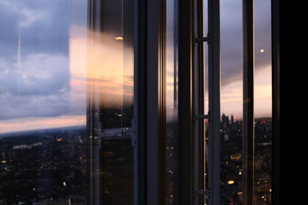 Captivating view of London's skyline at dusk, reflected through glass windows.