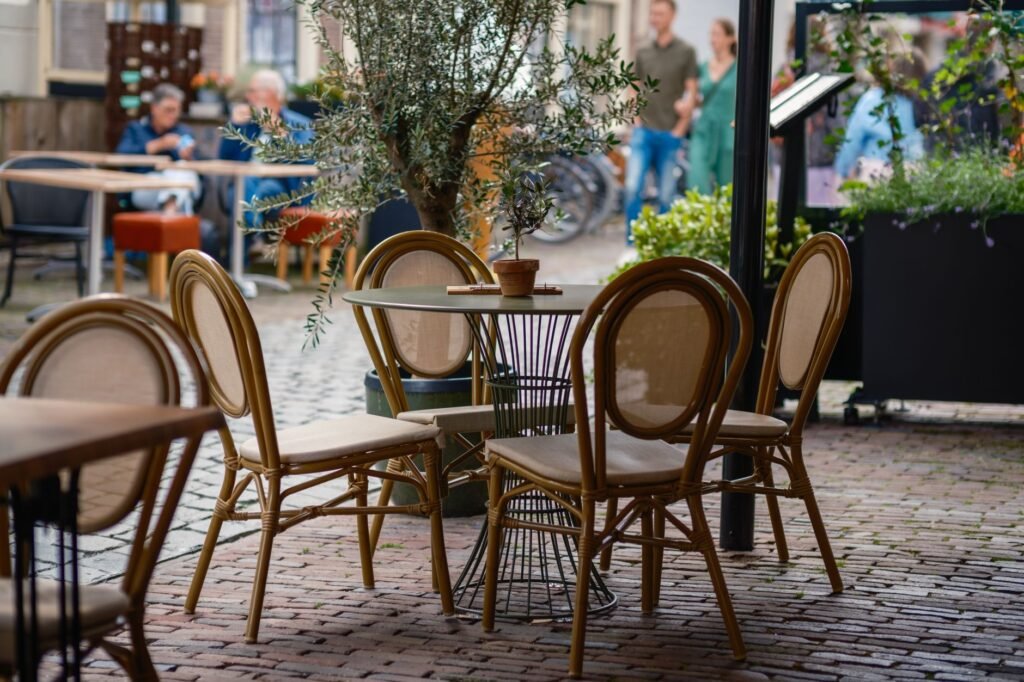 Charming outdoor cafe with empty wooden bistro chairs and tables, capturing the essence of terrace dining.