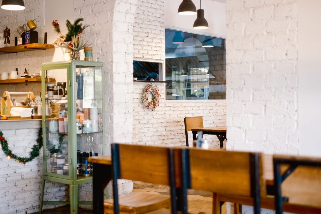 Quiet modern café interior with rustic decor, showcasing festive wreath and warm lighting.