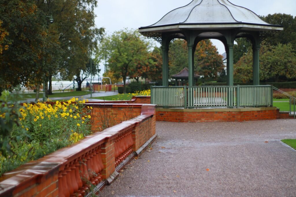 Quiet park scene featuring a classic gazebo surrounded by autumn foliage in England.
