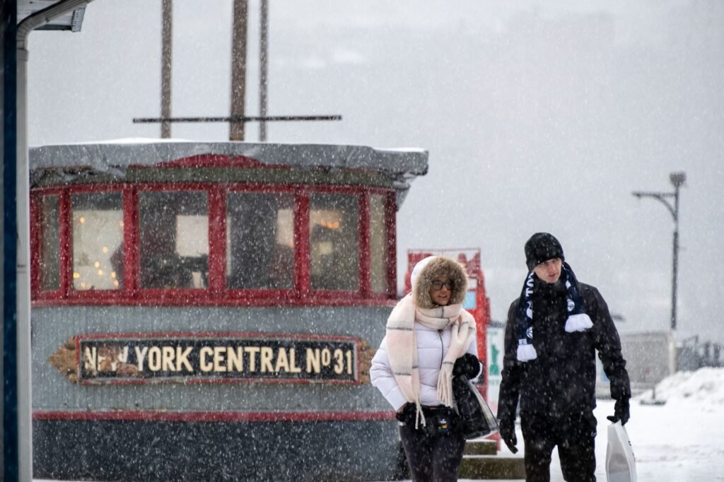 People walking in a snowy New York street amidst a winter storm.