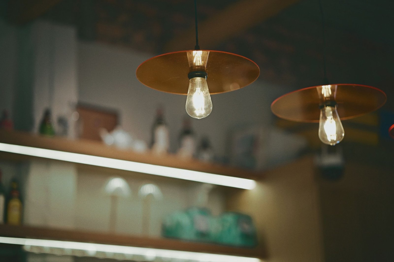 Cozy cafe interior featuring warm Edison bulb lighting and minimalistic decor.