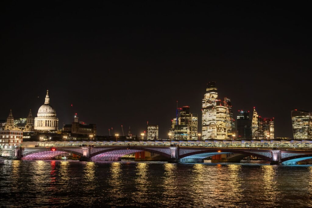 Night view of London's skyline featuring St. Paul's Cathedral and illuminated bridges over the River Thames.