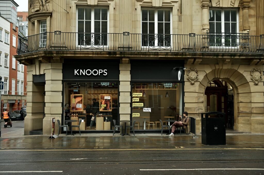 Street view of Knoops cafe on a rainy day, highlighting cozy urban vibes.