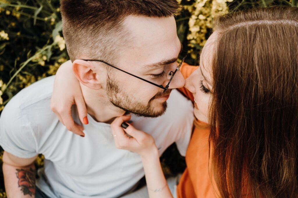 A close-up view of a couple embracing outdoors in a romantic and joyful setting.