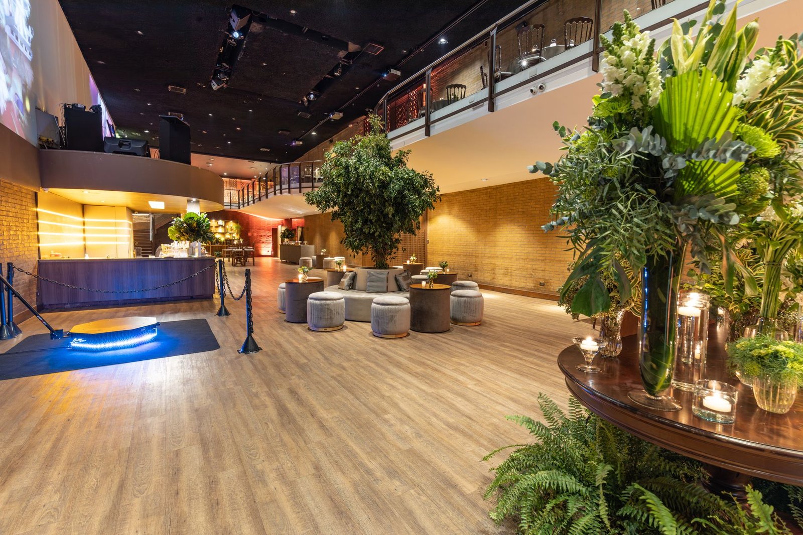 Spacious hotel lounge featuring modern furniture, plants, and a stylish bar, perfect for events or relaxation.