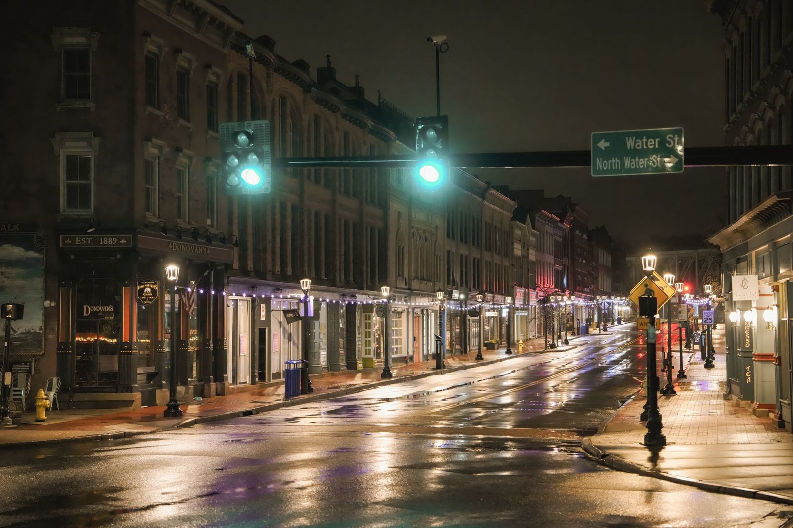 A quiet, illuminated street scene in downtown Norwalk after rain.