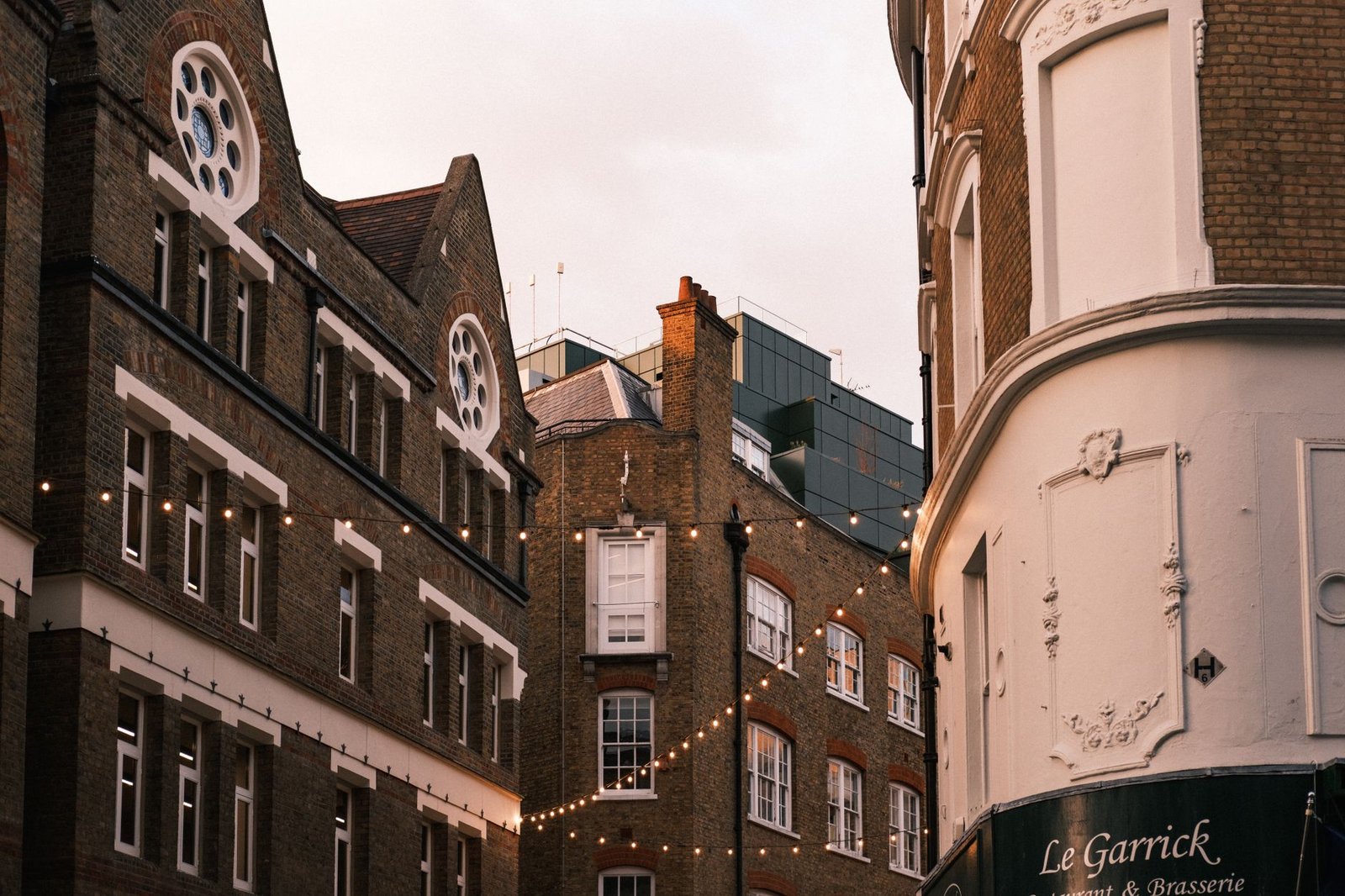Captivating view of historic London buildings adorned with string lights at twilight.