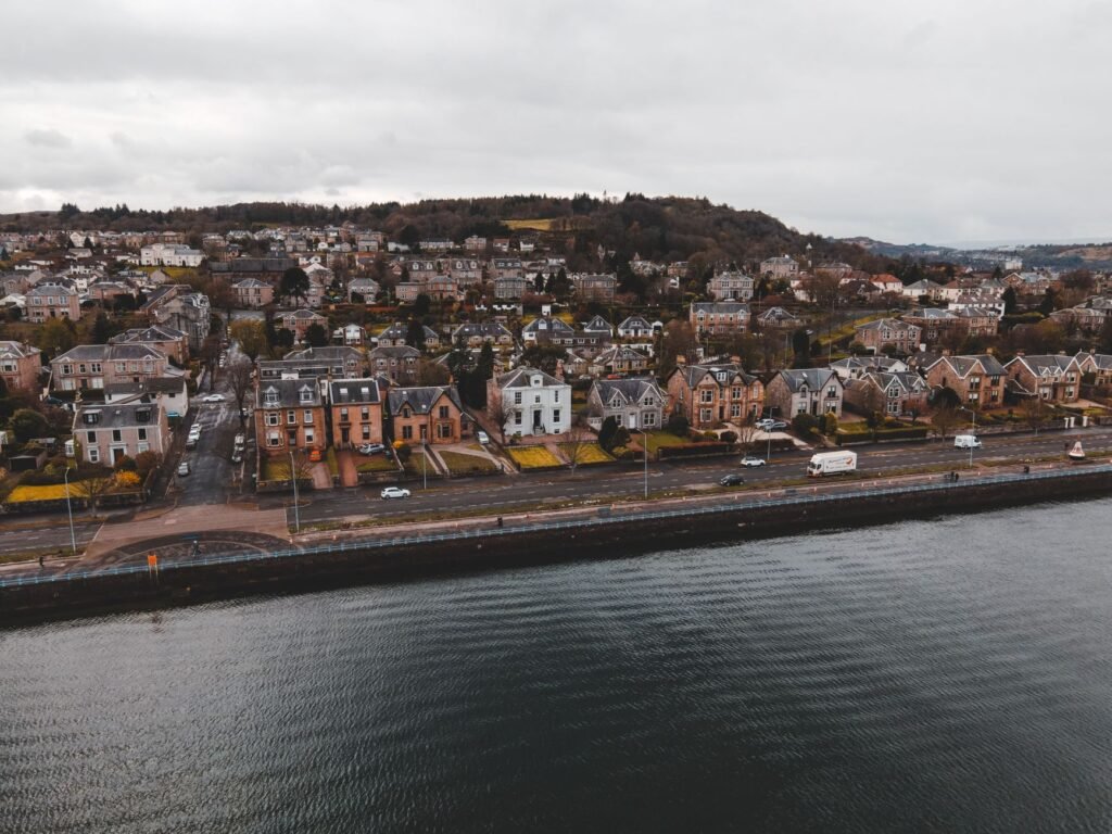 Scenic aerial view of Greenock's waterfront with charming houses and lush landscapes.