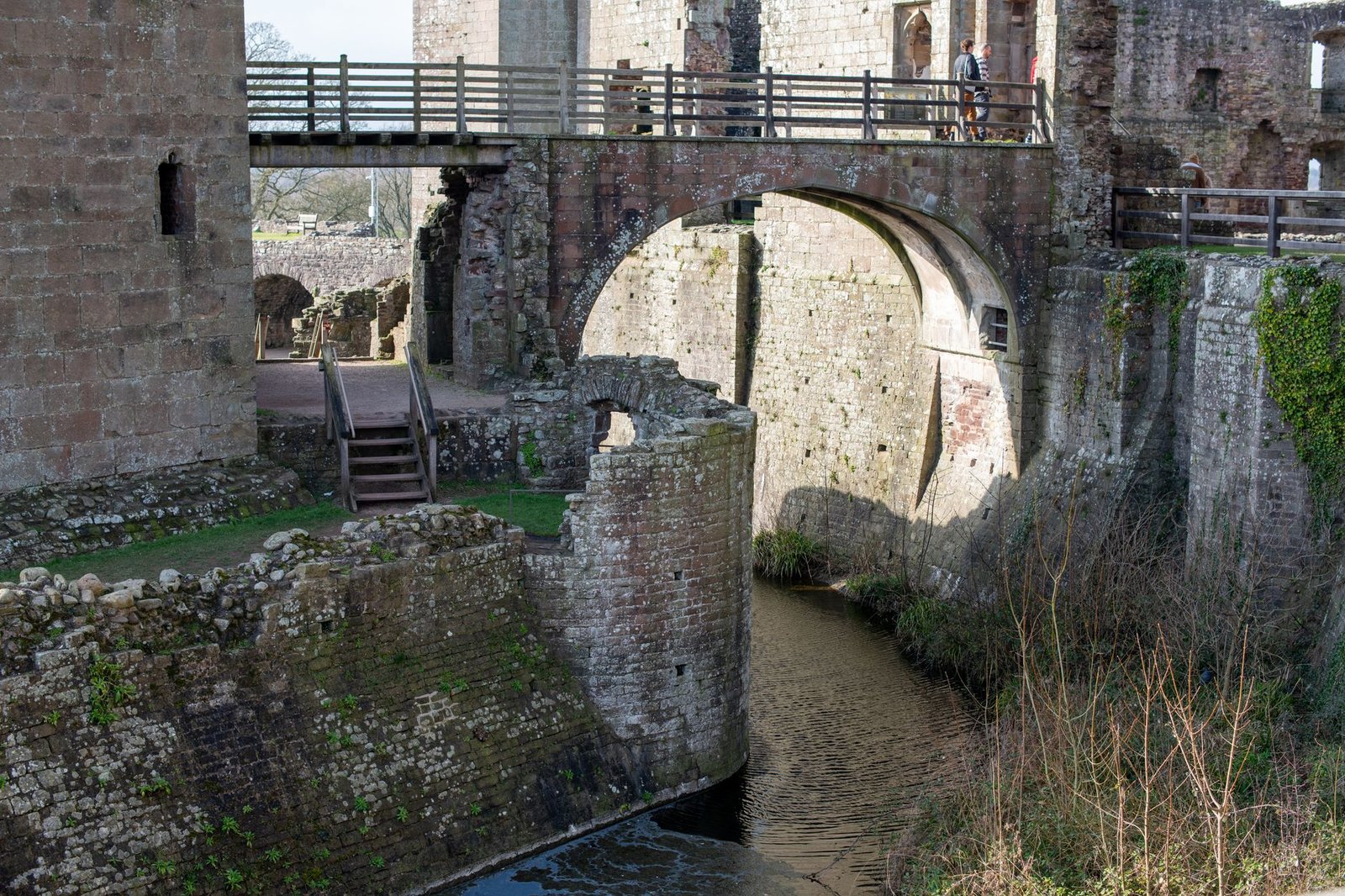 A detailed view of the stone archway and moat at Raglan Castle in Wales.