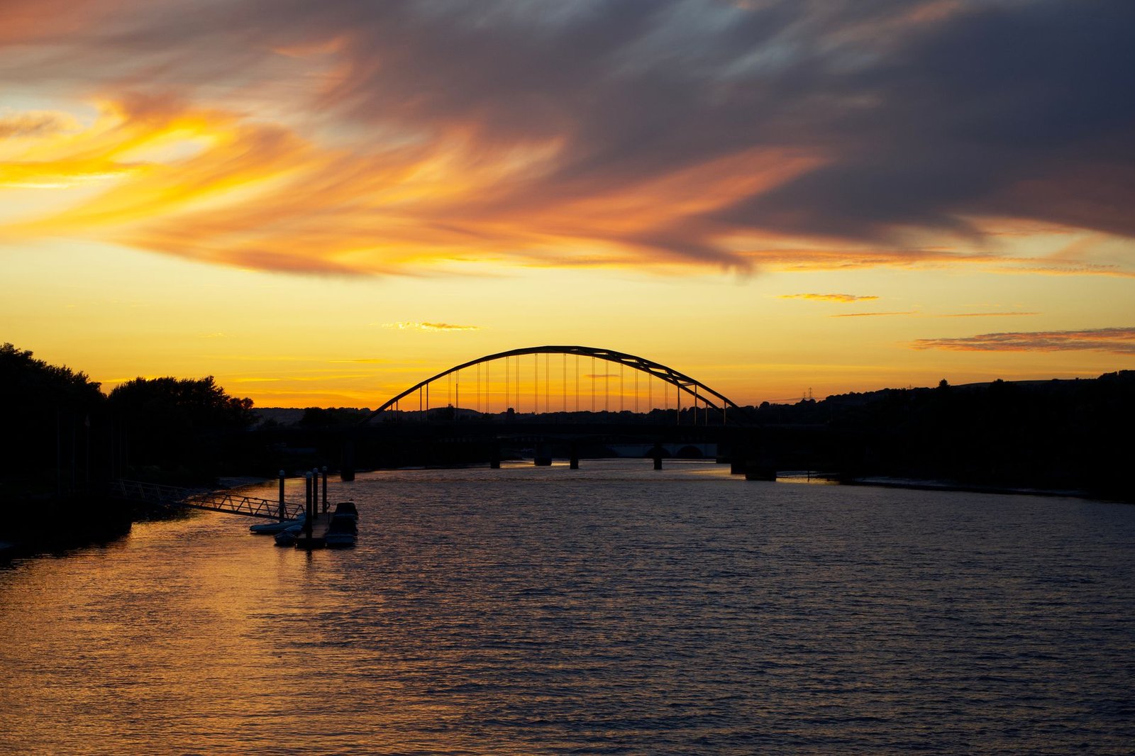 A stunning sunset with golden skies over a river bridge in Newcastle upon Tyne.