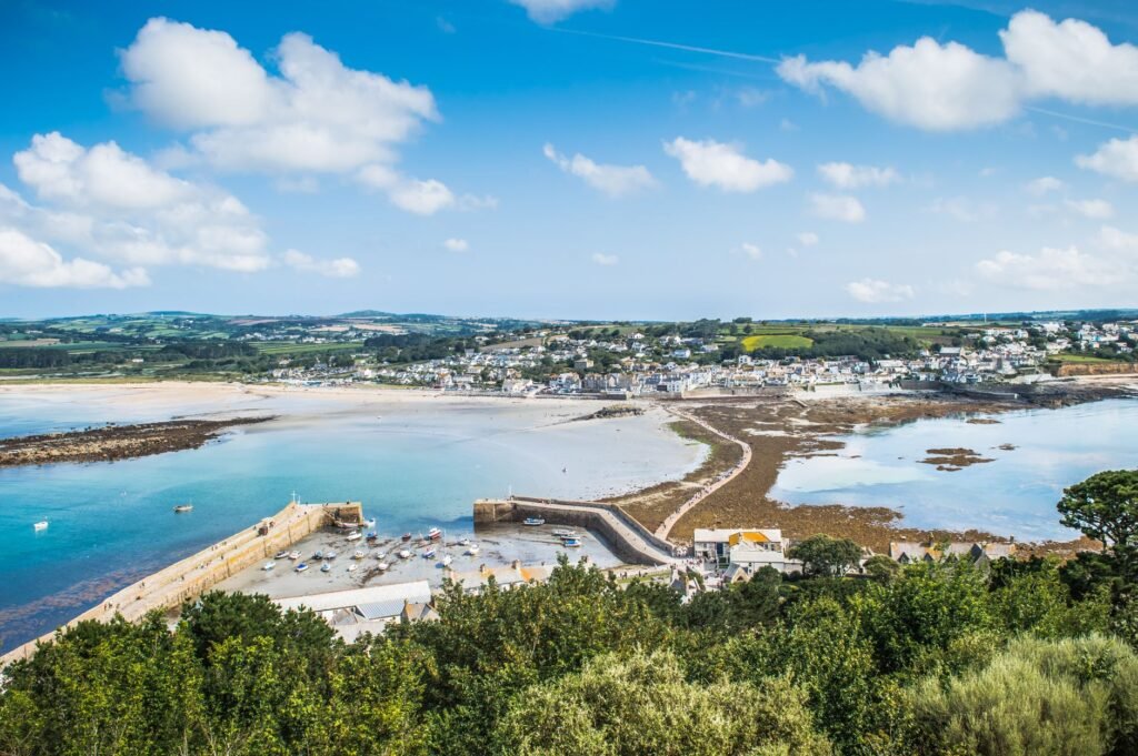 Beautiful aerial view of Marazion's coastline and marina with lush greenery and blue skies.