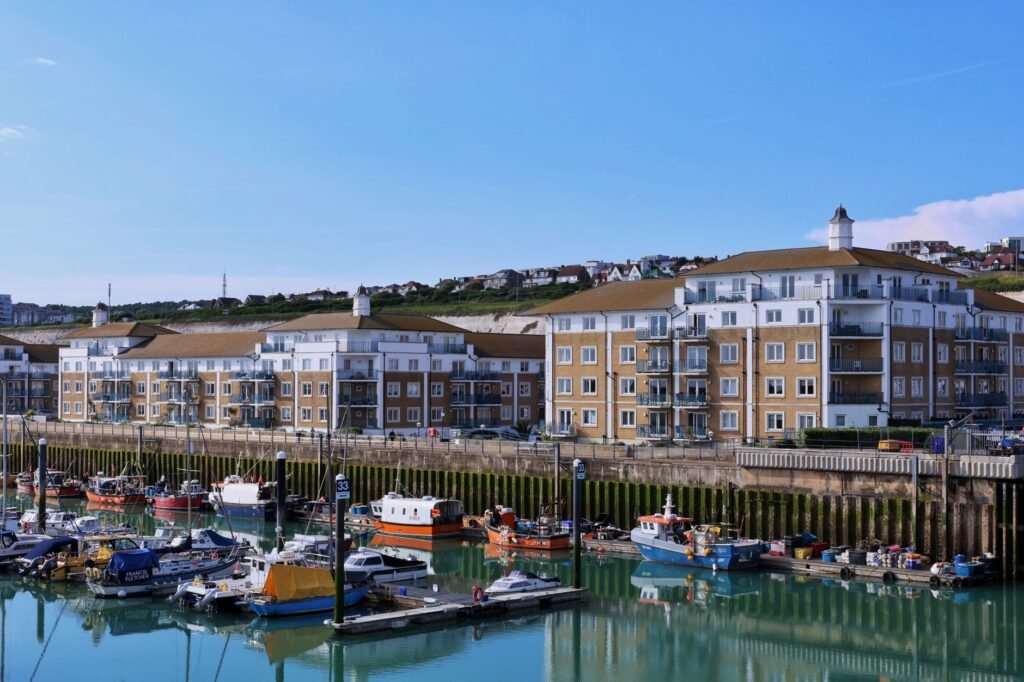 Scenic view of Brighton Marina with docked boats and modern residential buildings on a sunny day.