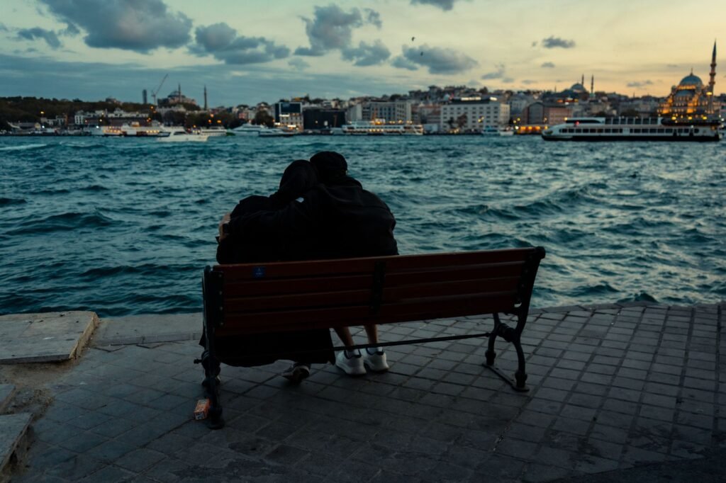 Romantic scene of a couple embracing by the waterfront in Istanbul at sunset.
