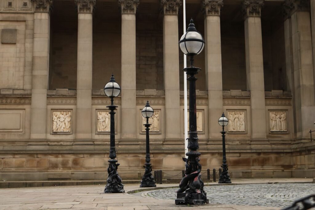 A classical colonnade with vintage street lamps in urban setting.