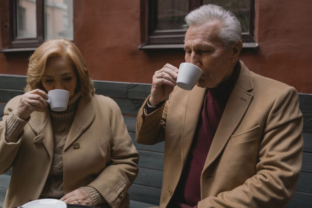 Senior couple enjoys warm coffee together, showcasing timeless companionship.