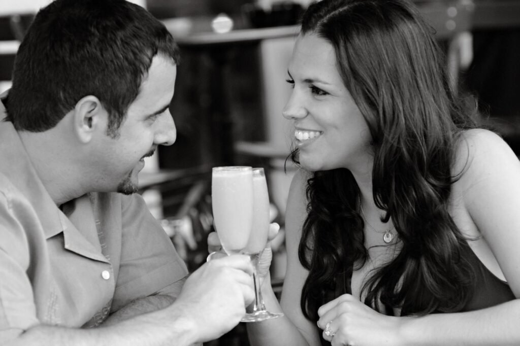 A couple enjoying a romantic moment with drinks at an outdoor café in Miami Beach.